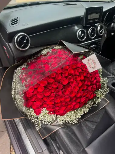 Hand-tied bouquet of fresh red roses with baby's breath